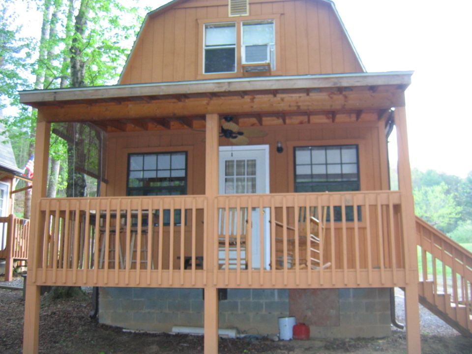 Wooden cabin with a covered porch and railing