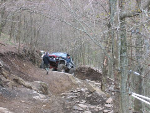 1992 Ford Mustang - An off-road vehicle tackles a challenging trail with steep inclines and rocky terrain.