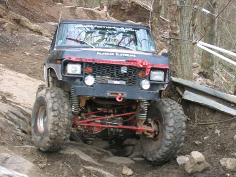 1992 Ford Mustang - This heavily modified off-road vehicle is tackling a challenging rocky incline.