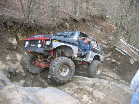 1992 Ford Mustang - This heavily modified pickup truck navigates a rocky off-road course, displaying 'ALL TERRAIN EXTREME' on its windshield banner.
