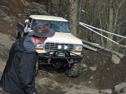 1992 Ford Mustang - A modified pickup truck navigates a challenging off-road course with a person filming from the passenger seat.