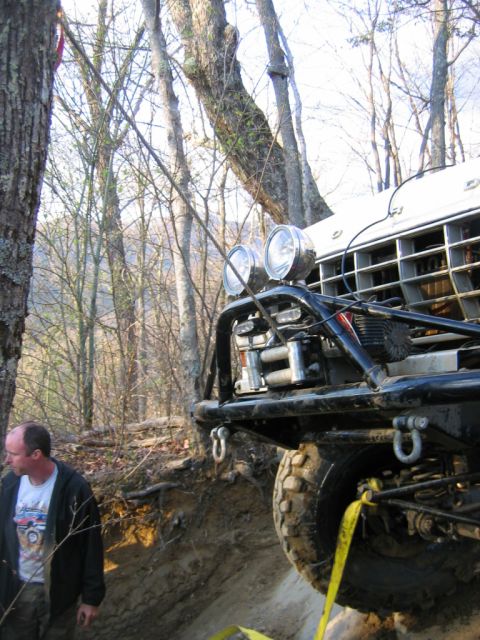 1992 Ford Mustang - A man stands near an off-road vehicle with a winch and auxiliary lights mounted on the front.