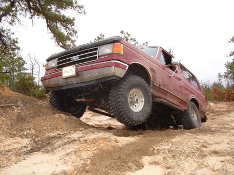 1991 Ford Bronco - This 1991 Ford Bronco navigates a challenging off-road course, demonstrating its capability on uneven terrain.