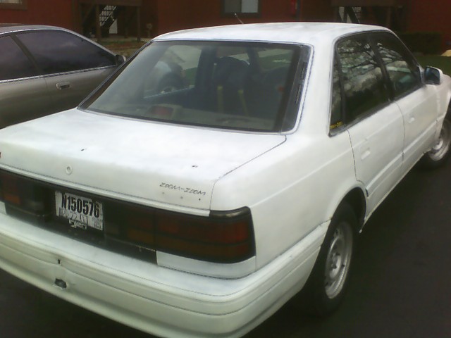 White sedan parked next to another car. License plate N150576 is visible