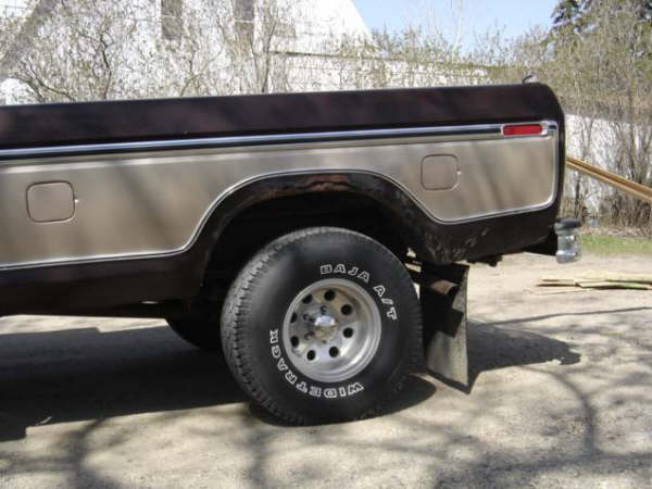 Side view of a 1970s pickup truck's rear wheel and quarter panel