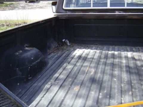 1979 Ford Bronco - The interior of a truck bed is shown from a rear-facing perspective.