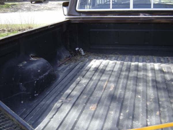 Truck bed interior with ribbed floor, dark color, and visible wheel well