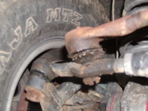 1991 Ford Bronco - Vehicle's front suspension tie rod end and tire detail.