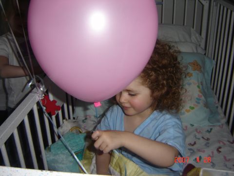 1993 Ford Bronco - A child sits in a crib, looking at a large pink balloon.