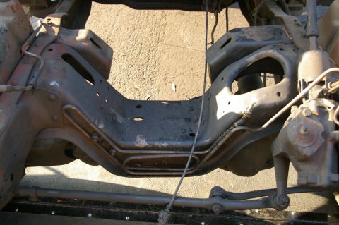 1986 Ford Bronco - Close-up of a vehicle's frame and steering components, showing rust and wear.