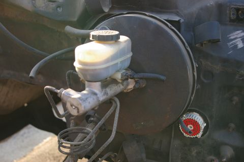 1986 Ford Bronco - Close-up of a brake master cylinder and booster assembly, likely from an older vehicle.
