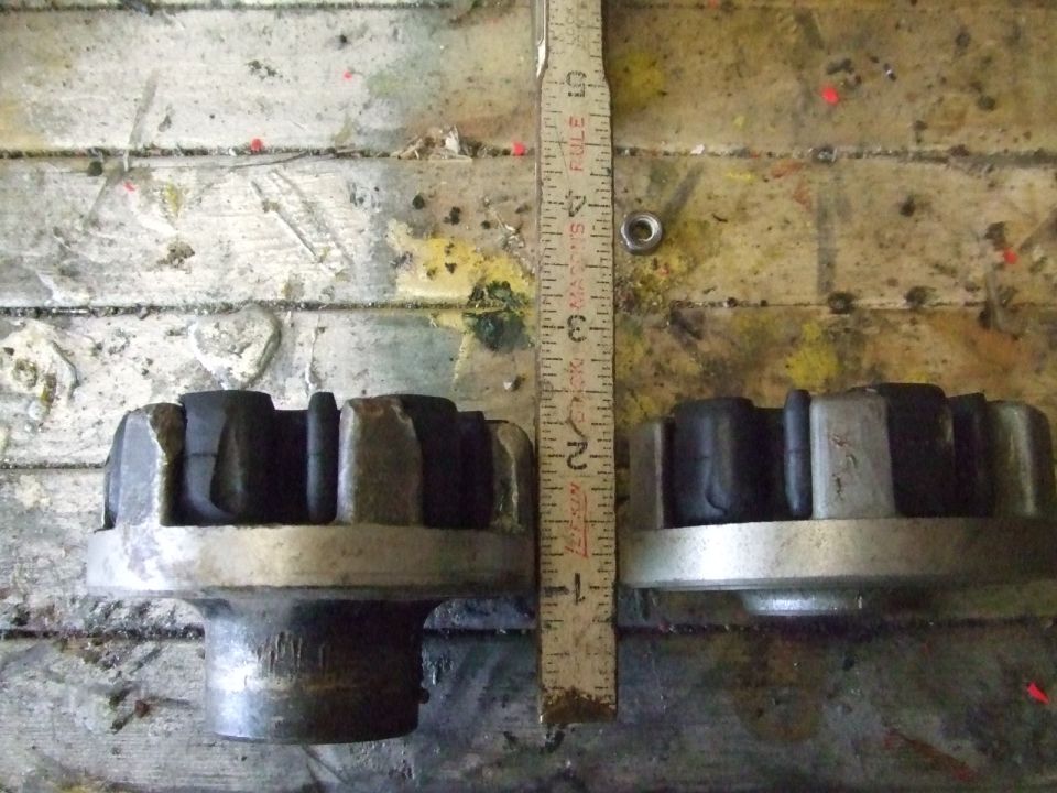 Two rubber and metal suspension parts side-by-side with a ruler for scale