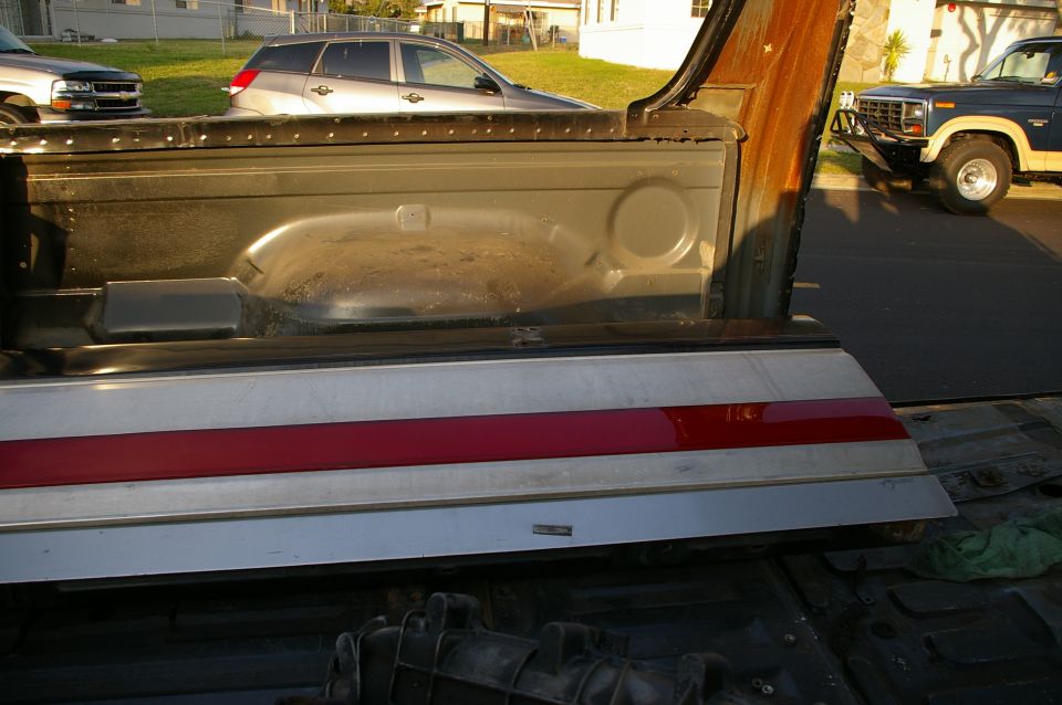 Rear of a blue Ford F-Series truck with a chrome grille and aftermarket bumper