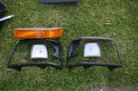 1986 Ford Bronco - Vehicle lighting components are displayed on a grassy surface.