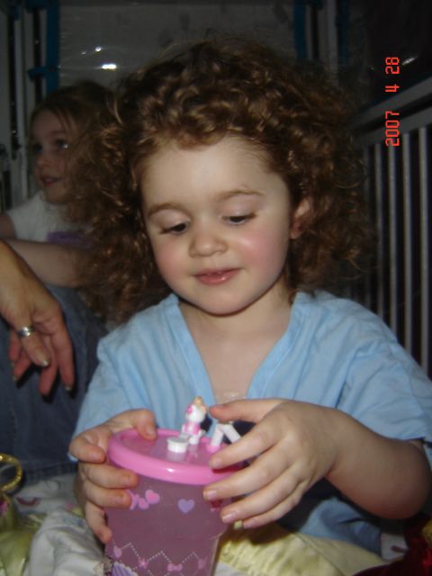 1993 Ford Bronco - A young girl with curly hair plays with a pink cup while another girl watches in the background.