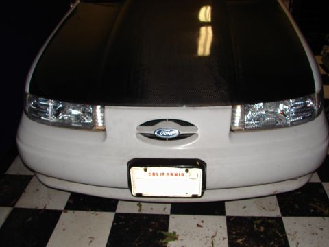 1992 Ford Taurus - The front of a 1992 Ford Taurus is shown, its headlights, Ford emblem, and a California license plate.