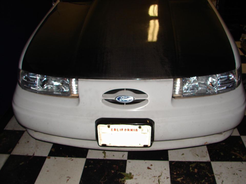 Front view of a 1992 Ford Taurus with a carbon fiber hood and California license plate
