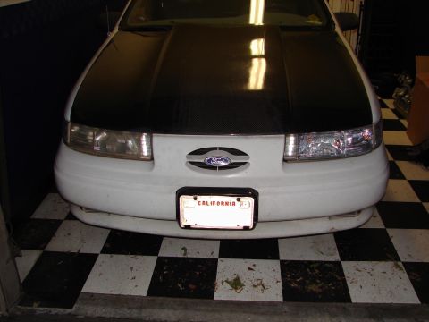 1992 Ford Taurus - 1992 Ford Taurus front end with a carbon fiber hood wrap and California plate.