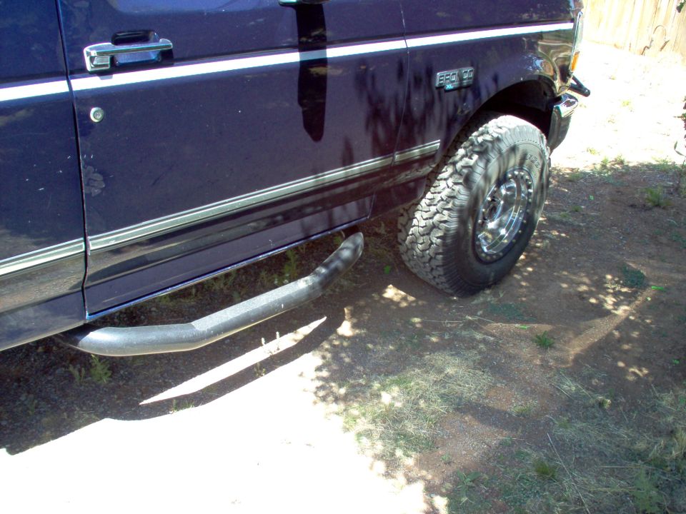Side view of a dark blue 1995 Ford Bronco with chrome trim and running boards
