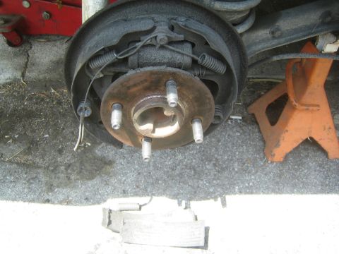 1985 Ford Mustang - A rear drum brake assembly is shown with detached brake shoes, indicating a brake repair or inspection.