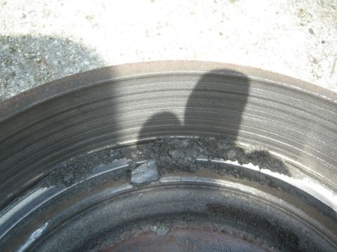1985 Ford Mustang - This brake rotor shows significant damage and wear, with pieces broken off the outer edge.