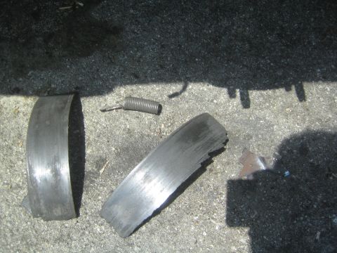 1985 Ford Mustang - Damaged brake drum components lie on the ground, suggesting a significant mechanical failure.