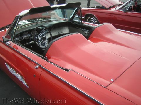 1990 Ford Bronco - red interior and dash of a Ford Thunderbird convertible, with another red Thunderbird visible behind it.