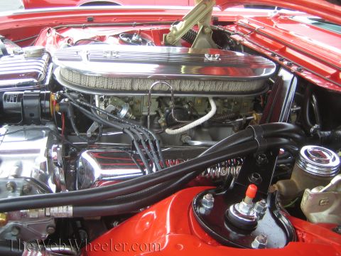 1990 Ford Bronco - Detailed engine bay of a red classic Ford Thunderbird with chrome valve covers, air cleaner, and black plug wires.