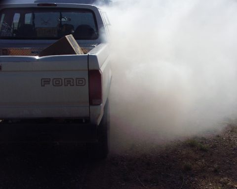 1997 Ford F-250 - A white 1997 Ford F-250 pickup truck is seen from the rear, heavily obscured by white exhaust smoke.