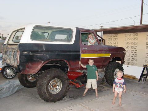 1979 Ford Bronco - A modified Ford Bronco sits in a driveway with three children posing around it.