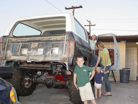 1979 Ford Bronco - A family poses with a disassembled vehicle, highlighting its exposed undercarriage and interior.