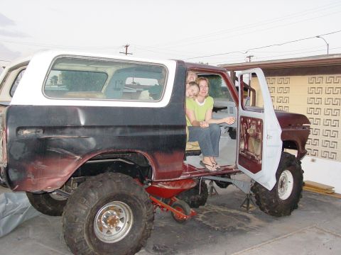 1979 Ford Bronco - This lifted 1979 Ford Bronco features a two-tone paint scheme and a white removable hardtop, with people visible inside the cabin.