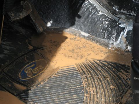 1990 Ford Bronco - The floor of this Ford vehicle is covered in mud and water, indicating it has been driven off-road.