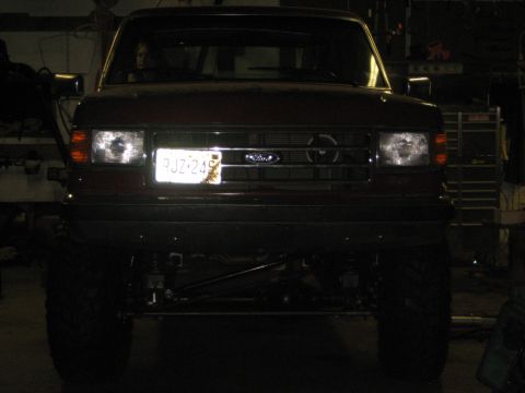1990 Ford Bronco - Frontal view of a red 1990 Ford Bronco, showing its grille and license plate.
