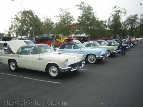 1990 Ford Bronco - lineup of 1950s Ford Thunderbirds, including a white hardtop and a light blue car, parked at an outdoor show.
