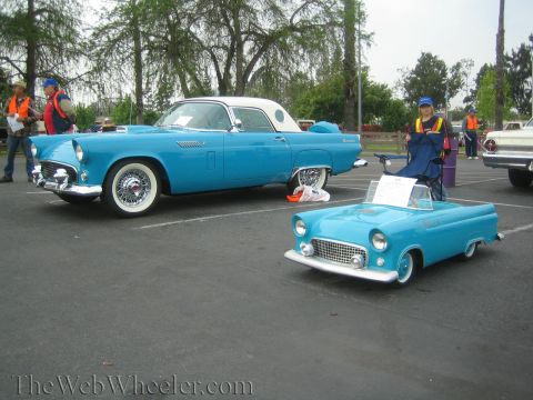 1990 Ford Bronco - blue early Ford Thunderbird parked next to a matching child-size Thunderbird pedal-style car at a show.