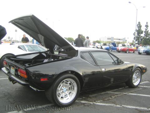 1990 Ford Bronco - Rear three-quarter view of a black mid-engine sports car with the engine deck lid raised at a car show.