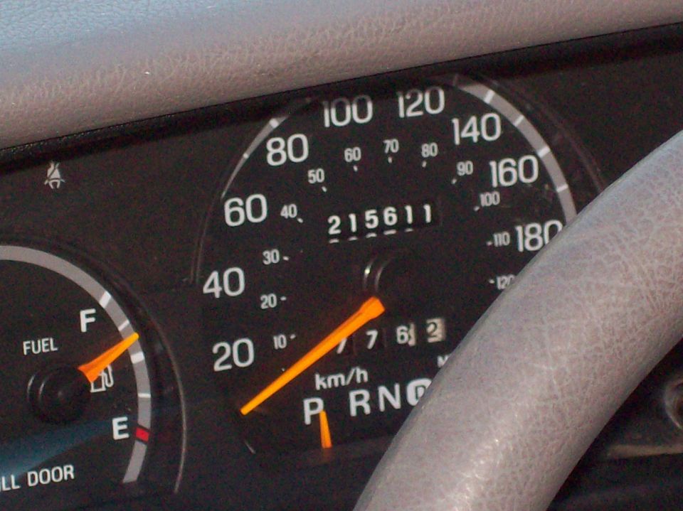 Instrument cluster close-up: km/h speedometer, odometer at 215611, fuel gauge near half