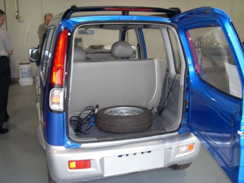 1992 Ford Bronco - Rear view of a blue SUV, showing the cargo area with a spare tire and tools.