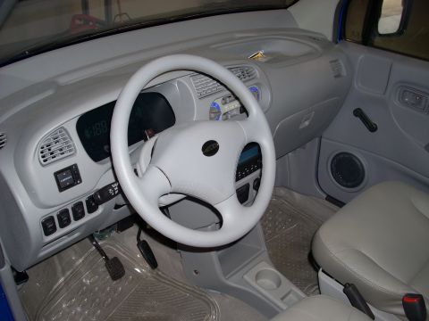 1992 Ford Bronco - The interior of a vehicle features a light gray dashboard, steering wheel, and seats.