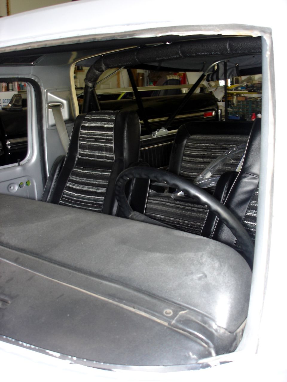 Interior view of a vehicle with striped seats and a roll cage