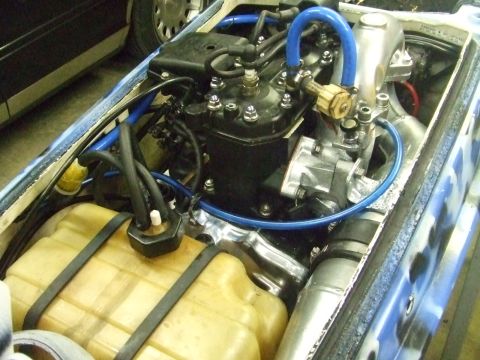 1995 Ford Mustang - The engine compartment of a personal watercraft, a complex arrangement of hoses, a fuel tank, and engine components.