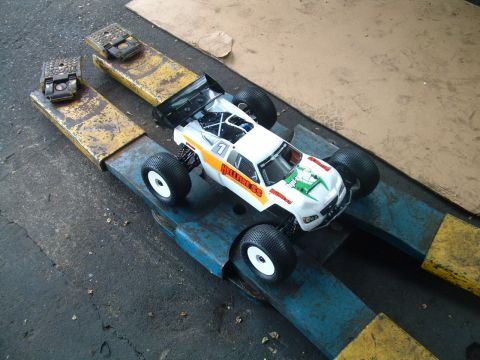 1994 Ford Bronco - RC monster truck with 'HELLFIRE SS' graphics sits on a vehicle lift.