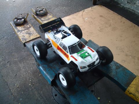 1994 Ford Bronco - A remote control monster truck with racing decals is positioned on a service stand.