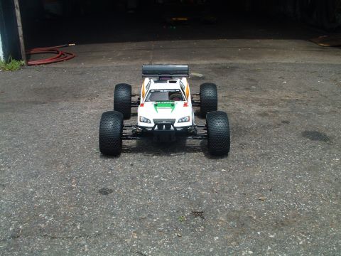 1994 Ford Bronco - This remote control car features a white body with green and yellow accents, large off-road tires, and a prominent rear spoiler.