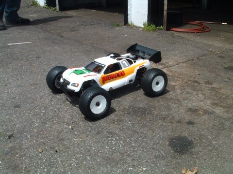 1994 Ford Bronco - A remote control monster truck with large tires and a rear spoiler sits on asphalt.