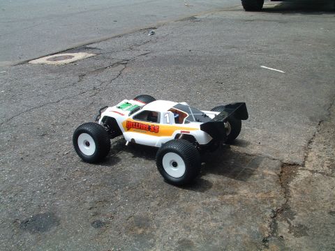 1994 Ford Bronco - A remote control monster truck sits on asphalt, showing off its 'HELLFIRE SS' branding and large tires.