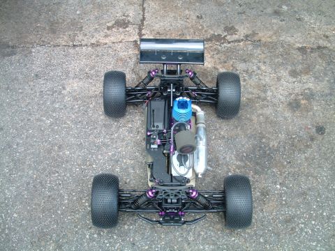 1994 Ford Bronco - Remote control nitro buggy with purple suspension components and knobby tires.