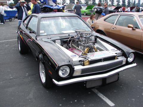 1992 Ford Taurus - A black coupe with a powerful engine modification is on display at an outdoor car show.