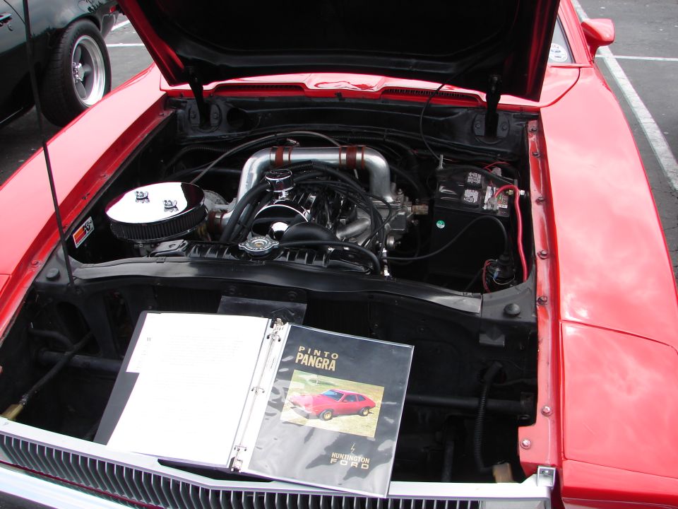 Red car engine bay with binder showing Pinto Pangra and Huntington Ford